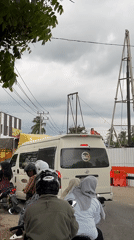 Motorcyclists wait in traffic behind van in Indonesian street