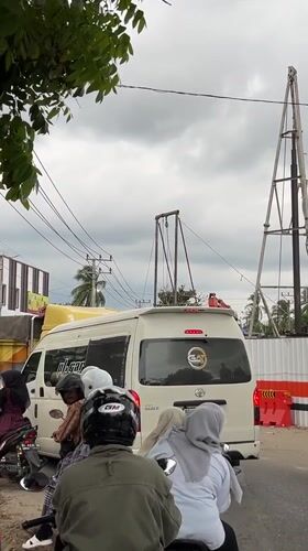 Motorcyclists wait in traffic behind van in Indonesian street