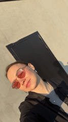 Woman in pink sunglasses poses on Chaikovsky rooftop