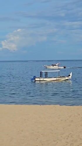 Morning beach life captured in Denpasar: cycling, sailing, music
