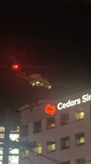 Military helicopter descends near Cedars-Sinai at night