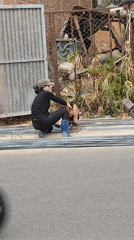 Woman cuts metal bars on street in Da Lat