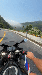 Motorcyclist travels winding road in Huế on sunny day