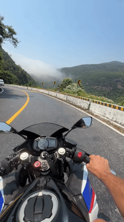 Motorcyclist travels winding road in Huế on sunny day