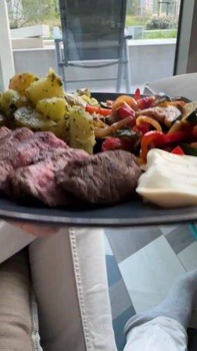 Person enjoys steak dinner with vegetables in Amsterdam