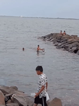 Children play soccer, swim near fishing boats in Lhokseumawe