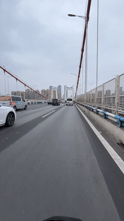 Vehicle crosses bridge in Jiulongpo District, China morning commute