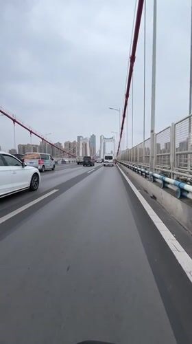 Vehicle crosses bridge in Jiulongpo District, China morning commute