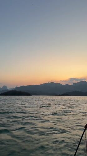 Sunset boat journey documented across Thai lake near Ban Chiao Lan