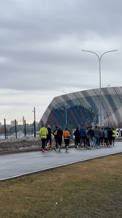 Morning joggers gather near Kazan Arena on cloudy day