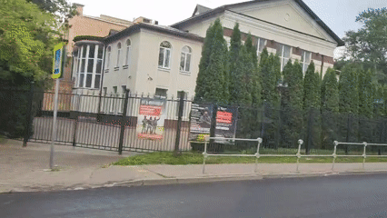 White building with mansard roof behind fence in Lytkarino