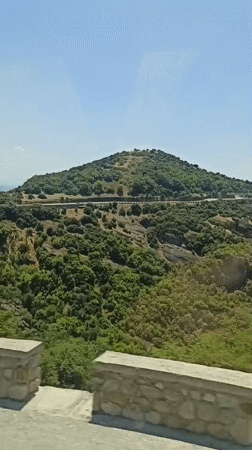 Rocky green hillsides and stone walls near Kastraki, Greece