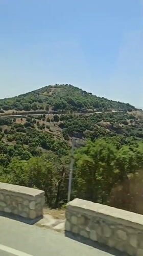 Rocky green hillsides and stone walls near Kastraki, Greece