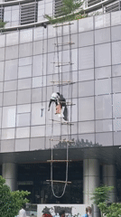 Men climb makeshift ladder against UNICEF building