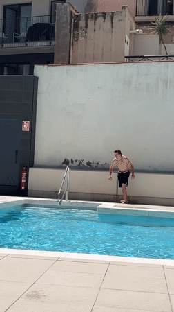 Young man enjoys rooftop pool morning in Barcelona