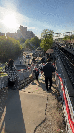 Group walks down train station overpass in Lyubertsy