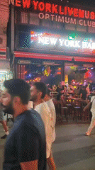 Patong nightlife strip buzzing outside neon-lit bars after rain