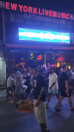 Patong nightlife strip buzzing outside neon-lit bars after rain