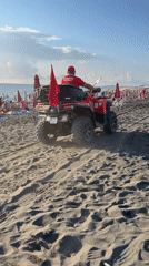 Lifeguard patrol and beachgoers on Ureki's black sand shore