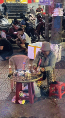 Street vendor sits outside Hội An Restaurant in Vietnam