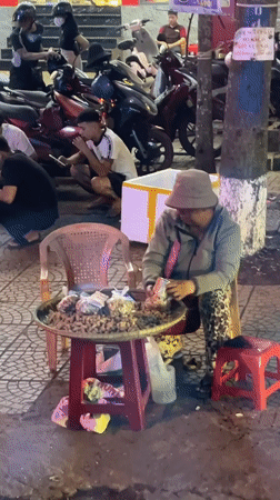Street vendor sits outside Hội An Restaurant in Vietnam
