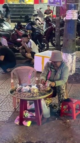 Street vendor sits outside Hội An Restaurant in Vietnam