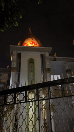 Illuminated mosque dome observed in nighttime Kaliwates street scene