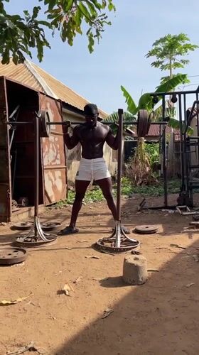 Man performs outdoor barbell squat workout in Akwanga, Nigeria
