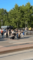 Busy Milan square captures street performers, fairground, pedestrians on sunny afternoon