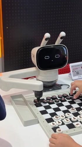 Boy plays chess with smiling robot in Futian District
