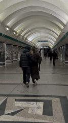 Couple walks together through Saint Petersburg subway station