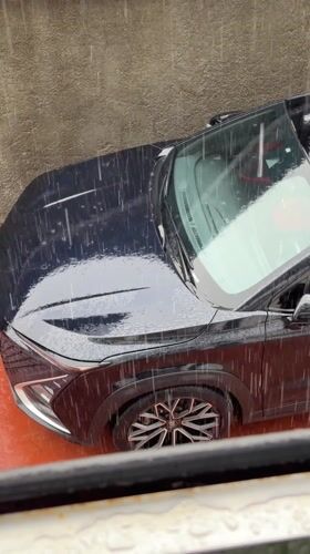 Dark SUV parked in rain in Igboefon, Nigeria