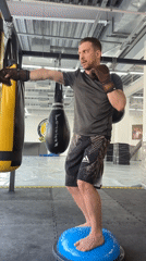 Man practices boxing exercises on balance ball in Perm gym
