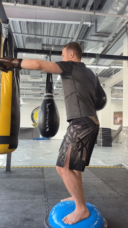 Man practices boxing exercises on balance ball in Perm gym