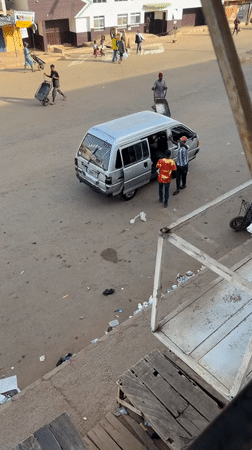 Morning street scene with vans and schoolchildren in Bukuru