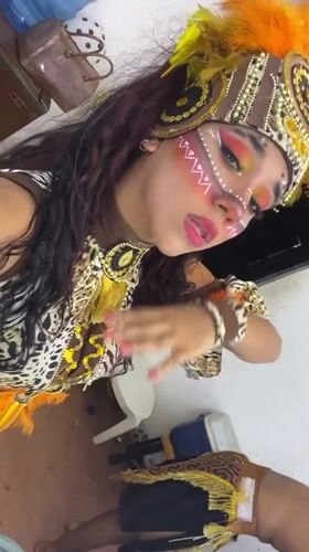 Costumed festival participants document elaborate tribal attire in Porlamar