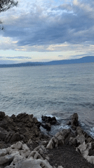 Rocky Croatian coastline with waves, clouds, and distant views