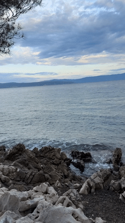 Rocky Croatian coastline with waves, clouds, and distant views
