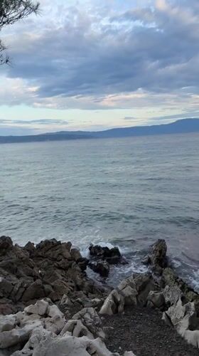 Rocky Croatian coastline with waves, clouds, and distant views