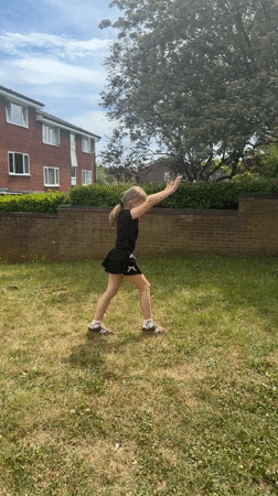 Girl practices gymnastics handstands in London backyard