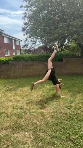 Girl practices gymnastics handstands in London backyard