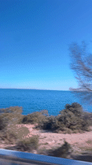 Traveler records coastal Mediterranean views from moving vehicle in Ibiza