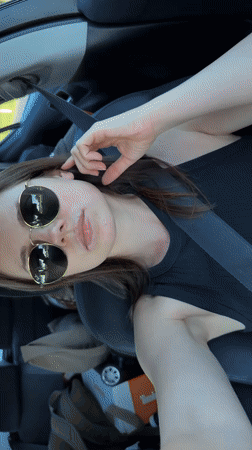 Woman in sunglasses sits in car in Černčice, Czechia