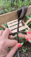 Hair braiding session documented in Russian garden setting