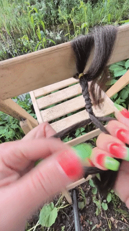 Hair braiding session documented in Russian garden setting