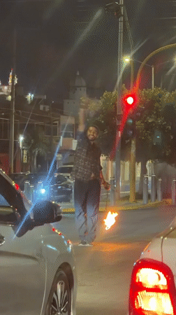 Man holds flaming torches in Cholula intersection at night