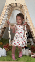 Toddler plays on indoor swing in Wisła, Poland