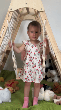 Toddler plays on indoor swing in Wisła, Poland
