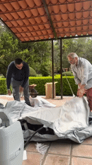 Men assemble inflatable pool as ducks roam Mexican garden