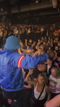 Person in blue jacket performs at Paris venue